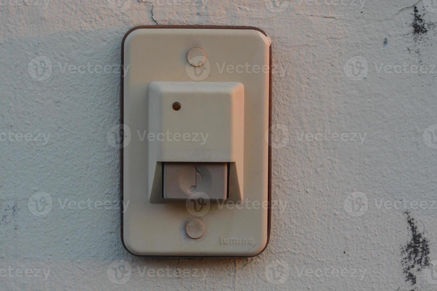 Close-up white doorbell on the old wall of the house. photo