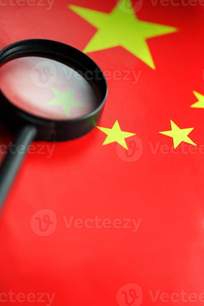The flag of the CHINESE PEOPLE'S REPUBLIC is looking through a magnifying glass. The study of the history and culture of a large country and the people of China. The concept of studying the geography photo