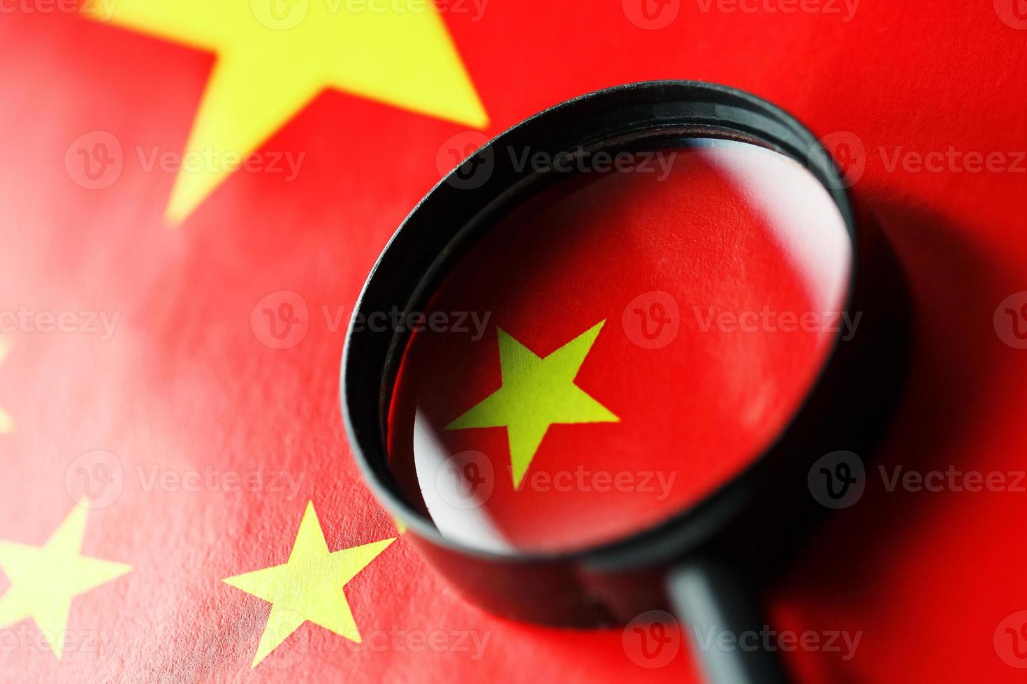 The flag of the CHINESE PEOPLE'S REPUBLIC is looking through a magnifying glass. The study of the history and culture of a large country and the people of China. The concept of studying the geography photo