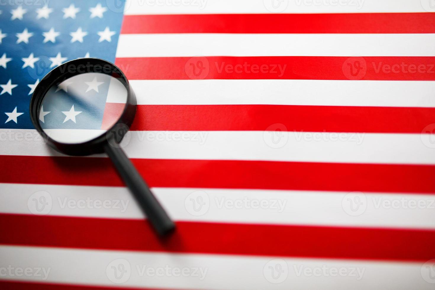 The US flag looks through a magnifying glass. Total surveillance of the United States. The concept of hidden threats and control over the country photo