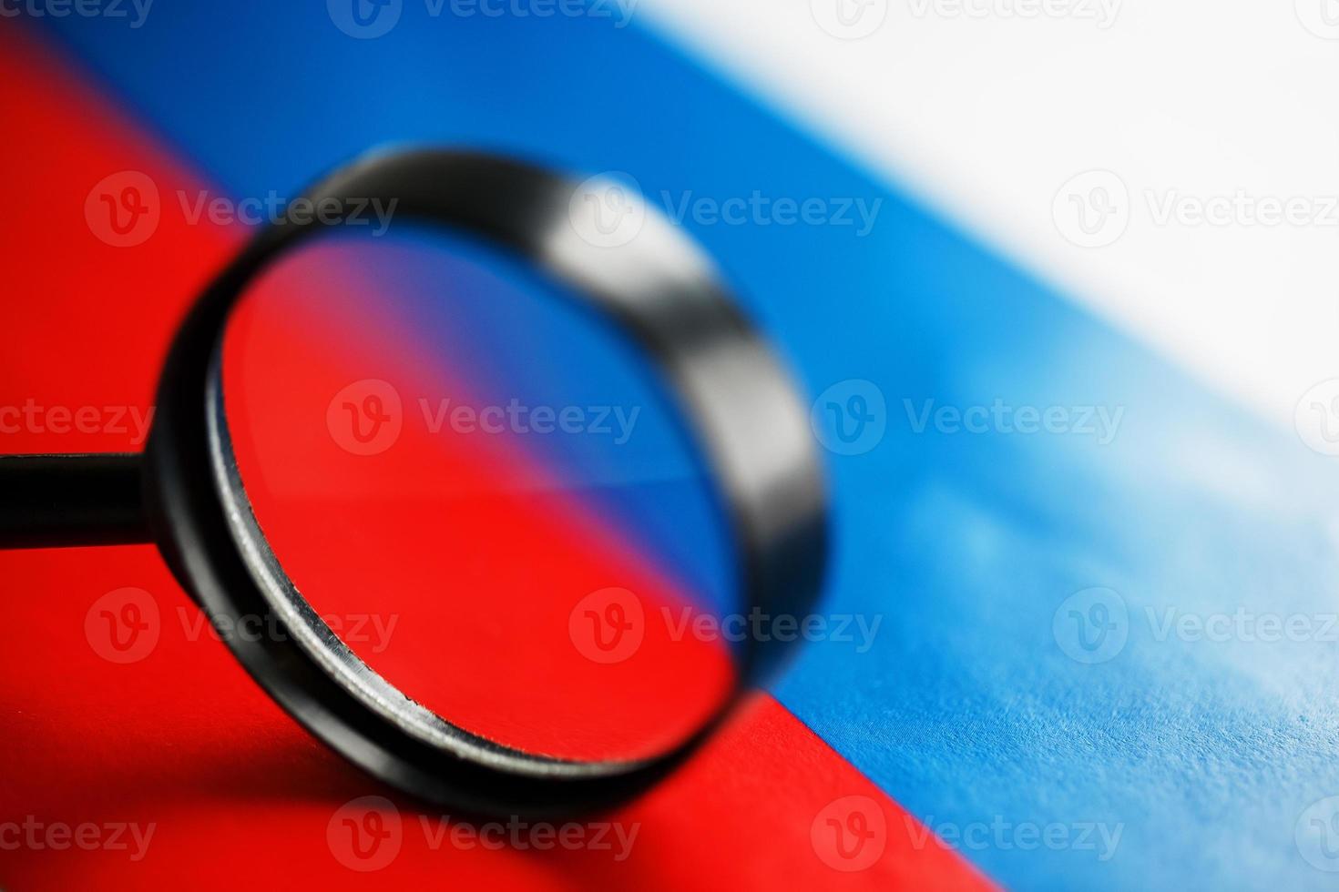 Flag of Russian Federation looking through a magnifying glass. Total surveillance of the country Russia. The concept of hidden threats and control over the country photo