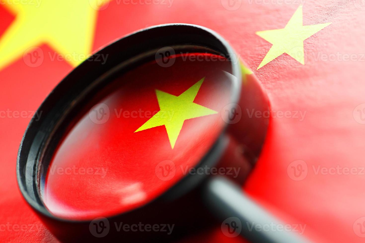 The flag of the CHINESE PEOPLE'S REPUBLIC is looking through a magnifying glass. The study of the history and culture of a large country and the people of China. The concept of studying the geography photo