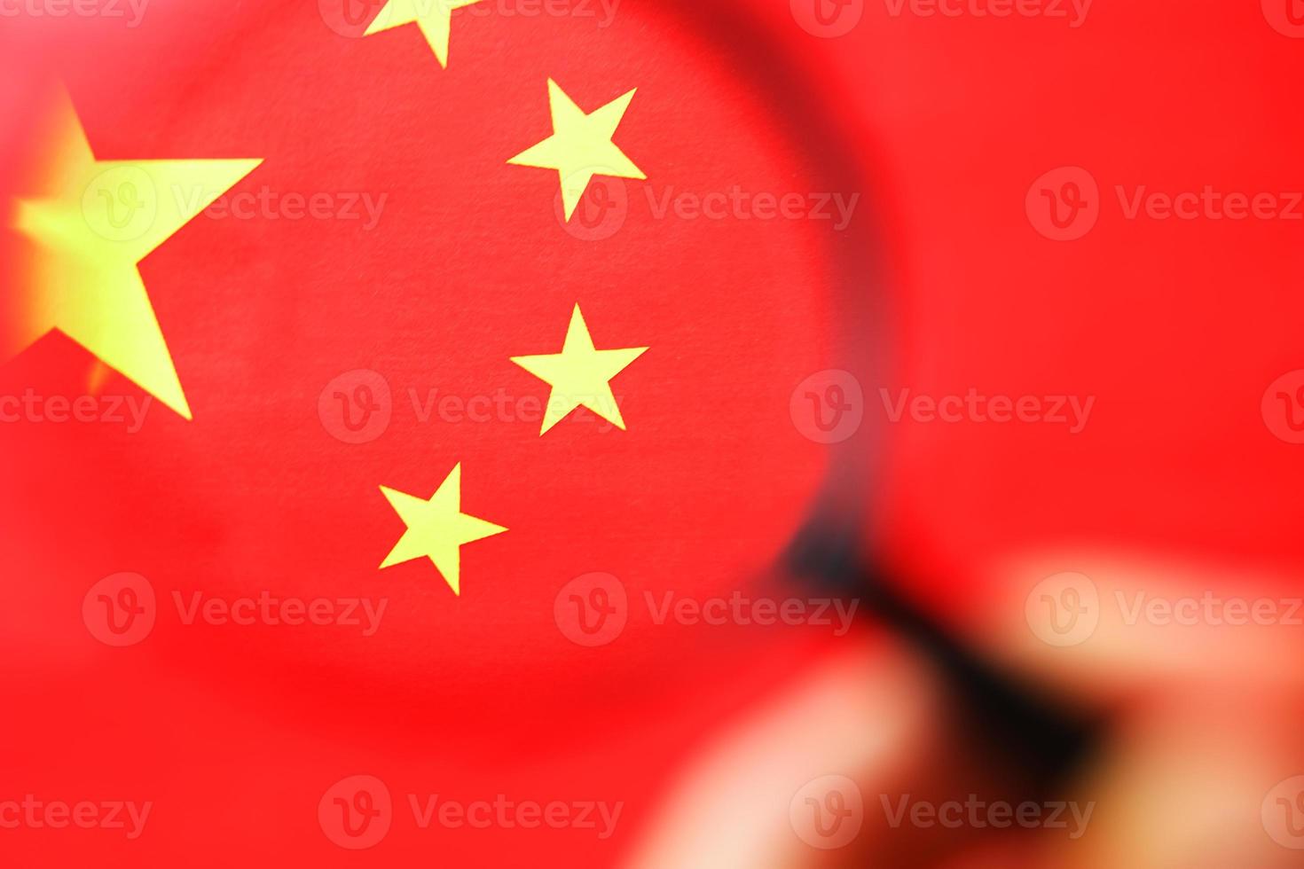 la bandera de la república popular china está mirando a través de una lupa. el estudio de la historia y la cultura de un país grande y la gente de China. el concepto de estudiar la geografía foto