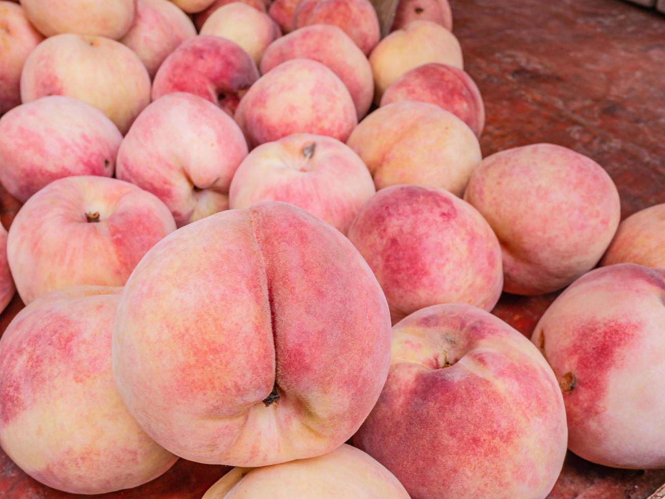 cierre las frutas de durazno chino en la canasta en la tienda de frutas en china foto