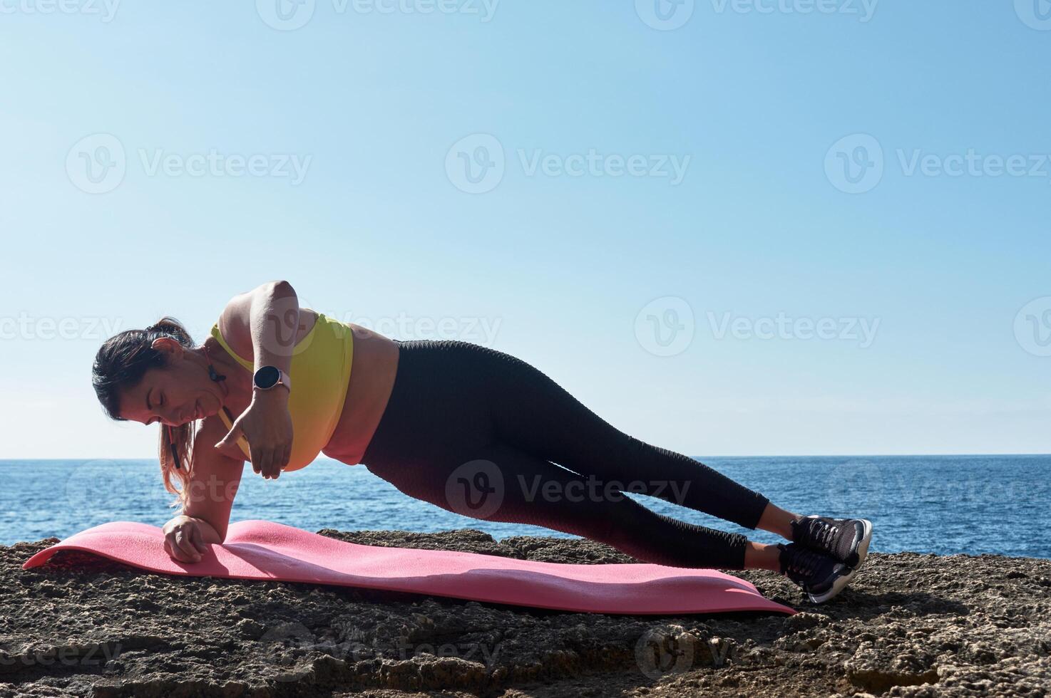 mujer fitness en entrenamiento deportivo con banda elástica, pesas, ejercicios de gimnasia, frente al agua. foto