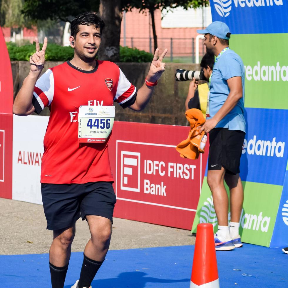 nueva delhi, india - 16 de octubre de 2022 - carrera de media maratón de vedanta delhi después de covid en la que los participantes del maratón están a punto de cruzar la línea de meta, media maratón de delhi 2022 foto