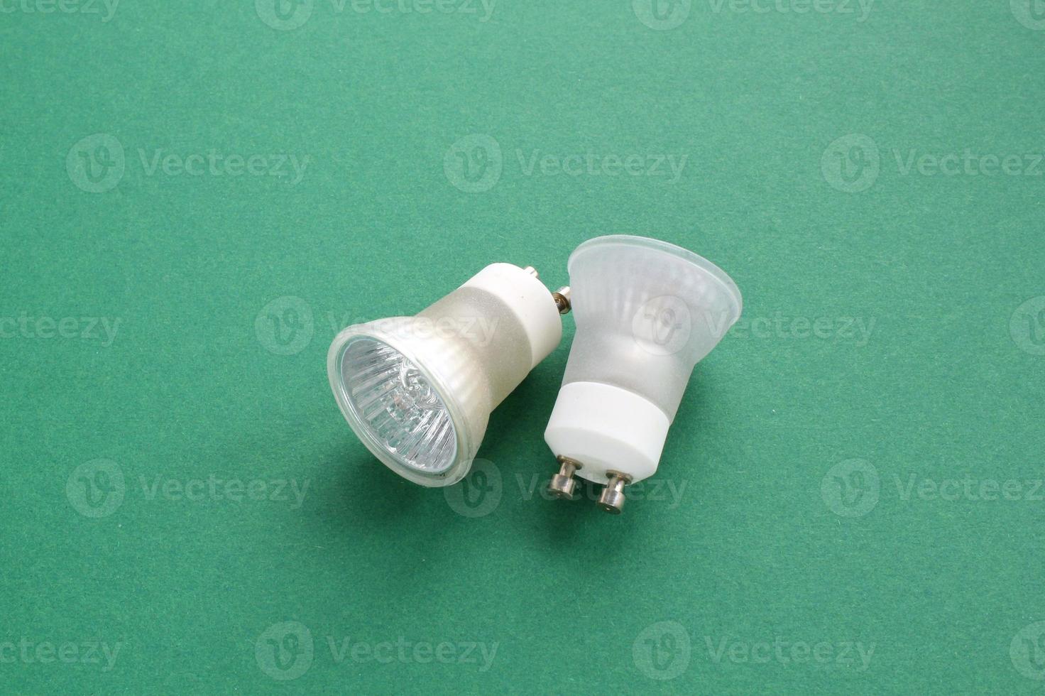 Electric LED light bulbs lamp on green background with copy space. Eco saving power and environmental conservation energy efficiency concept. Ecological friendly and sustainable lifestyle. Flat lay photo