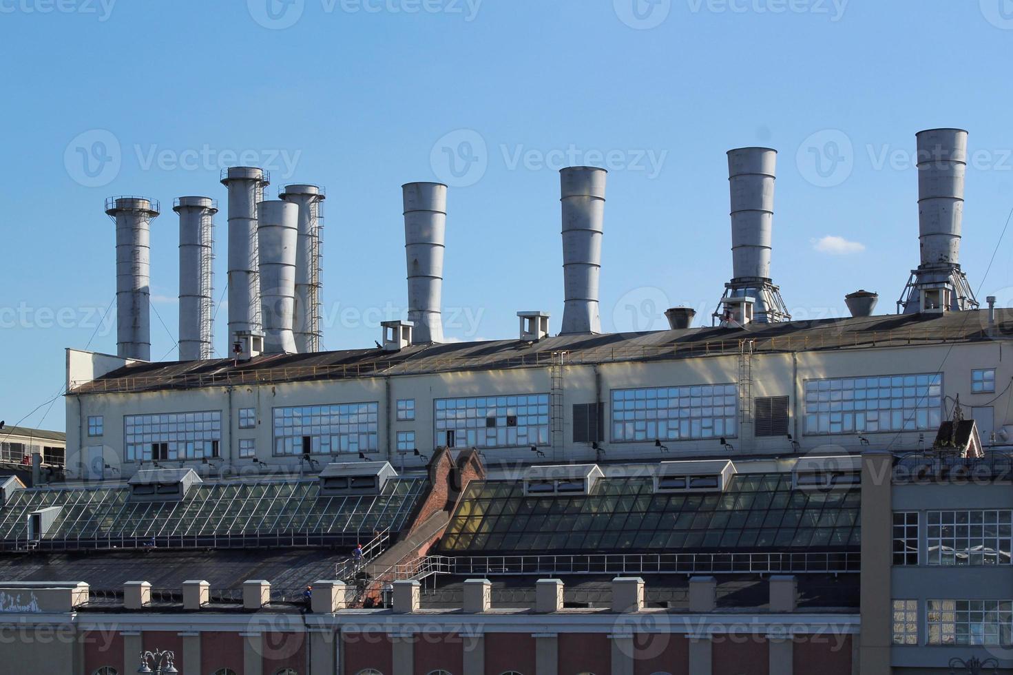 Pipes of thermal power plant on a town. Industrial zone in the city. Producing electrical energy concept. Ecological and environmental issues. System of electricity supply. Saving resources efficient photo