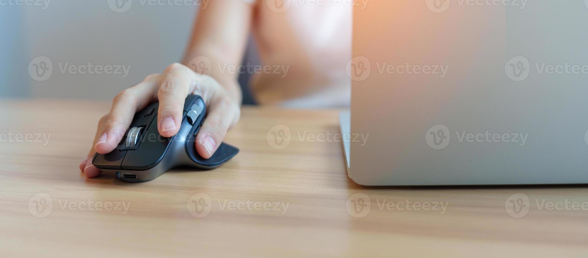 mano de mujer usando un mouse vertical ergonómico durante el trabajo en un escritorio ajustable, prevención del dolor de muñeca. tenosinovitis de de quervain, síntoma de intersección, túnel carpiano o concepto de síndrome de oficina foto