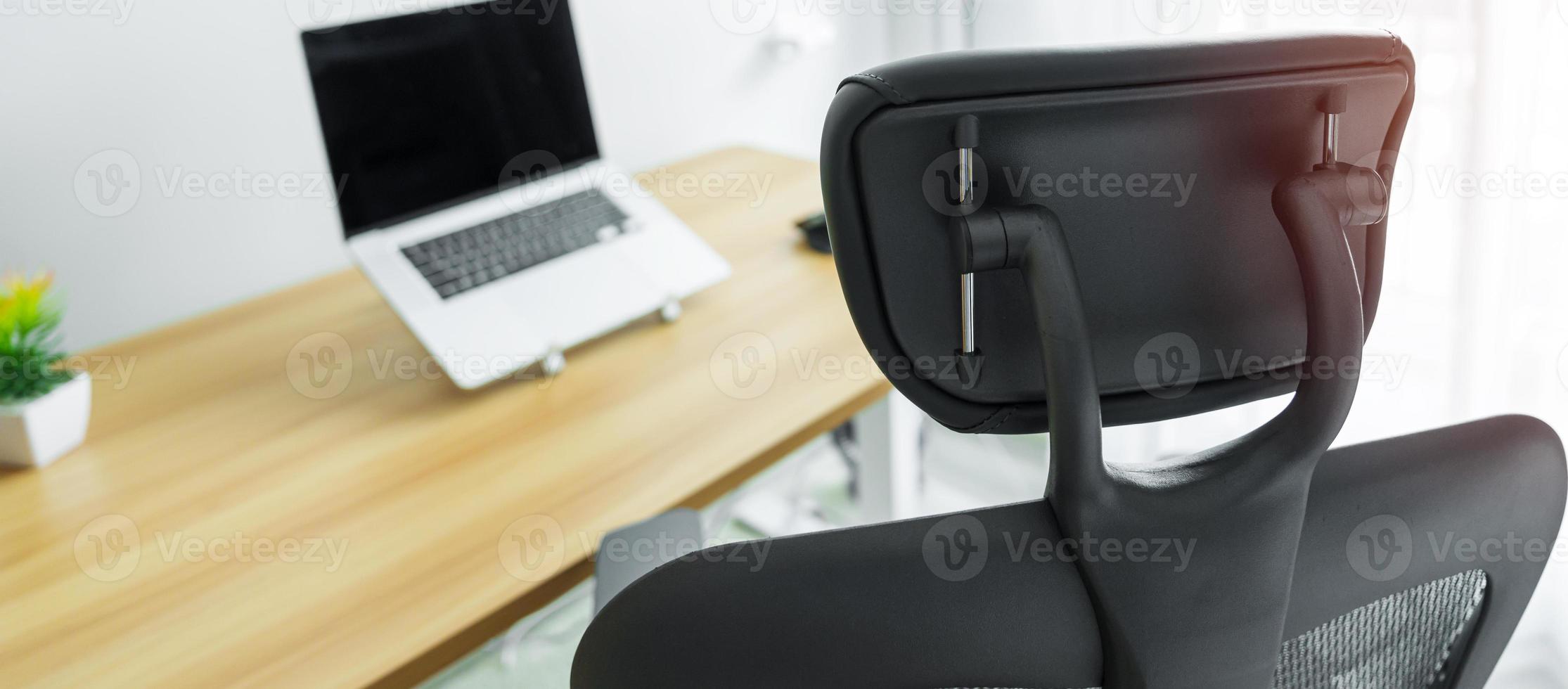 silla ergonómica y mesa ajustable con computadora portátil en un lugar de trabajo moderno. buena postura para evitar el síndrome de oficina, dolor de espalda, dolor de hombro, fibromialgia y dolor de cuello foto