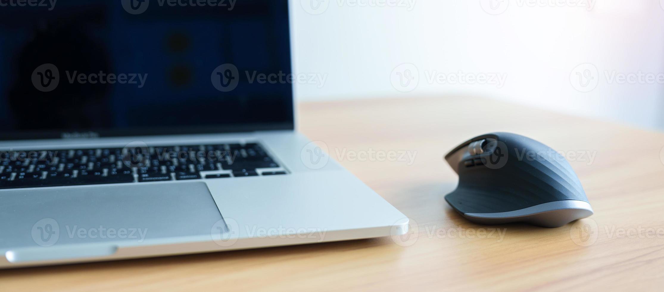 Ergonomic vertical mouse with laptop computer on adjustable desk at workplace, prevention wrist pain. De Quervain s tenosynovitis, Intersection Symptom, Carpal Tunnel or Office syndrome concept photo