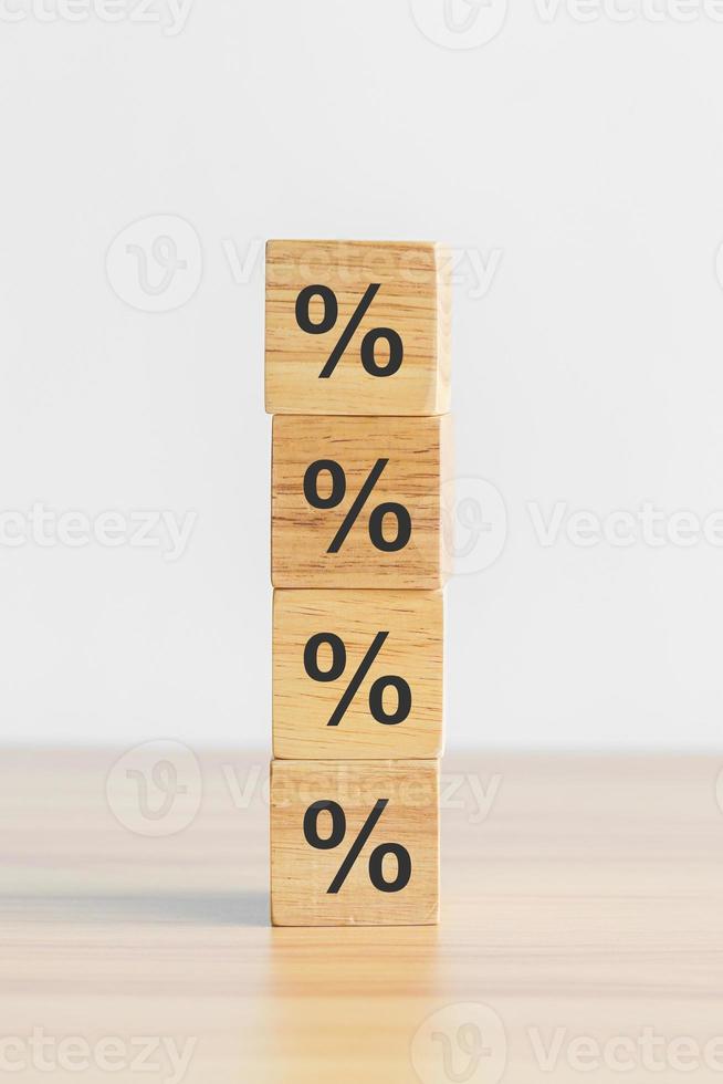 bloque de madera con icono de símbolo de porcentaje. concepto de tipos de interés, financieros, inflación, recesión, clasificación e hipotecas foto