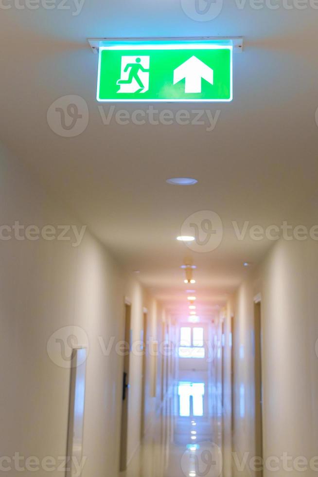 Fire Emergency exit sign on the wall background inside building. Safety concept photo