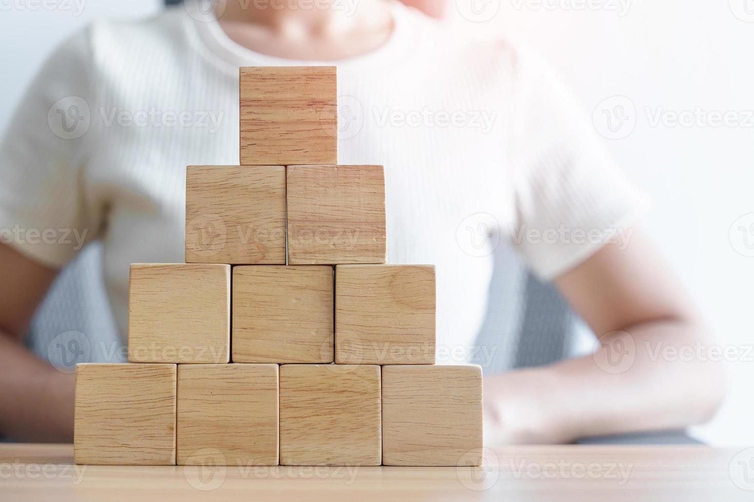 Woman hand placing wood block on the building. Leadership, Business process planning, Risk Management and strategy Concepts photo