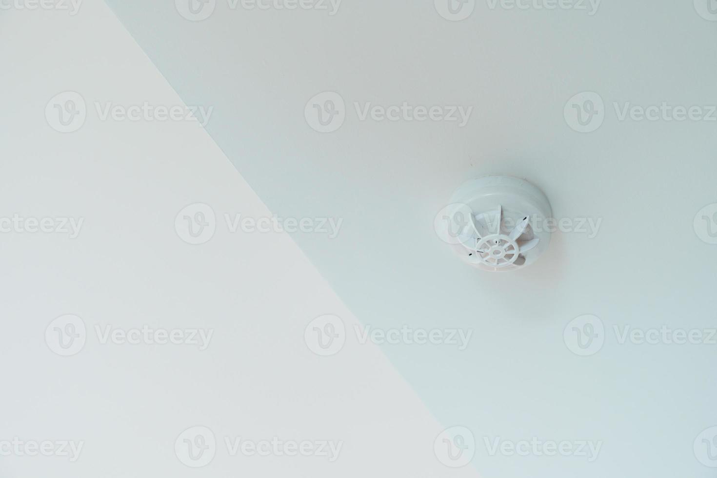 detector de sensor de humo montado en el techo de casa o apartamento. concepto de seguridad y seguridad contra incendios foto