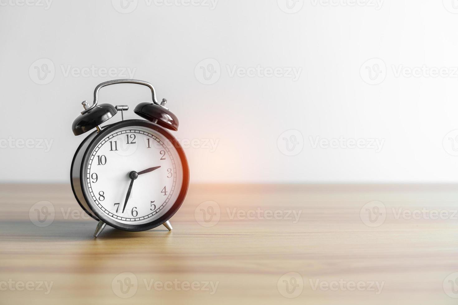 reloj despertador vintage sobre mesa de madera y espacio para copiar texto. actividad, rutina diaria, tarde, entrenamiento y concepto de equilibrio de vida laboral foto