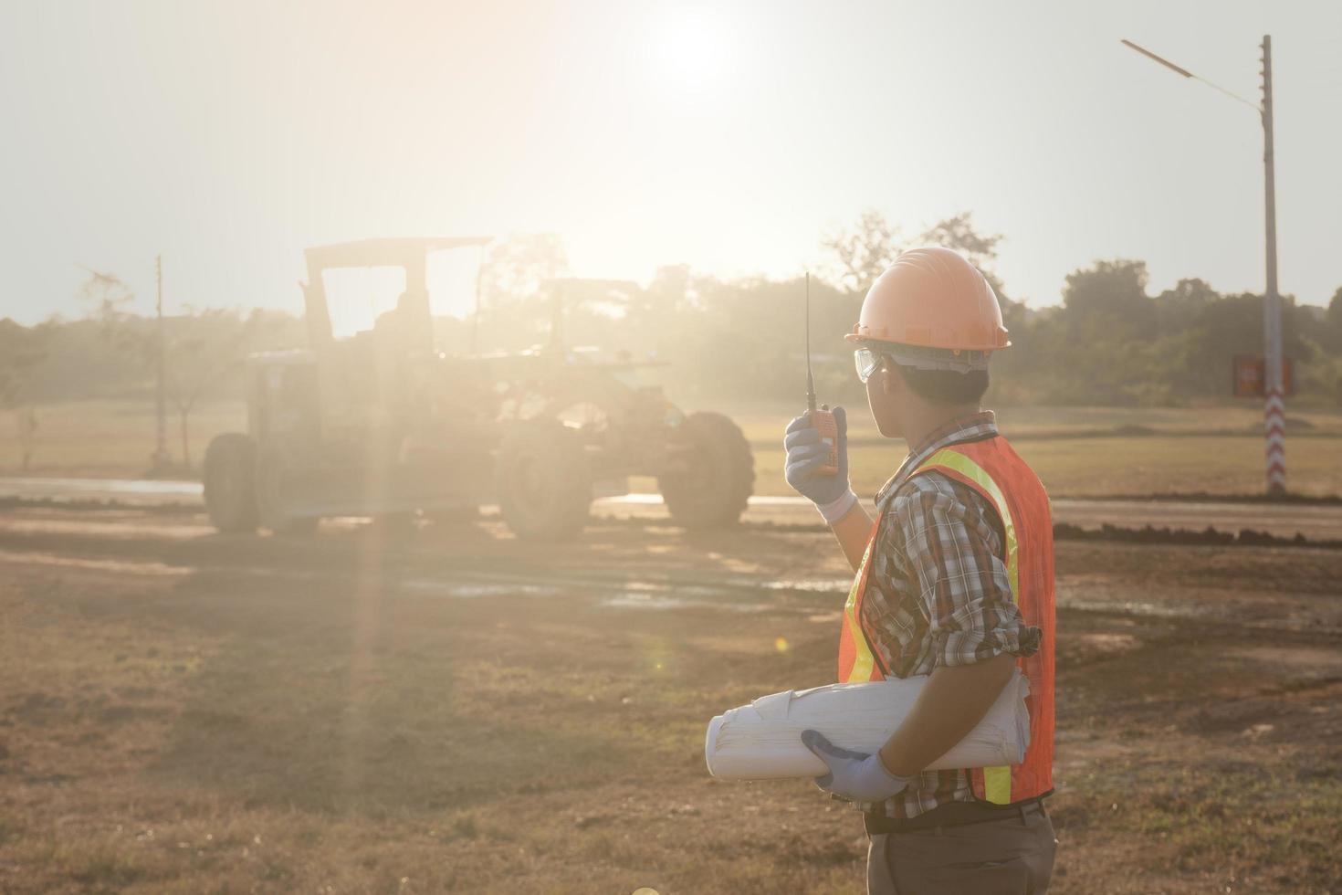 Worker  holding radio operate and control the worker employee to road construction. Young  road construction working at  construction site talking with radio. photo