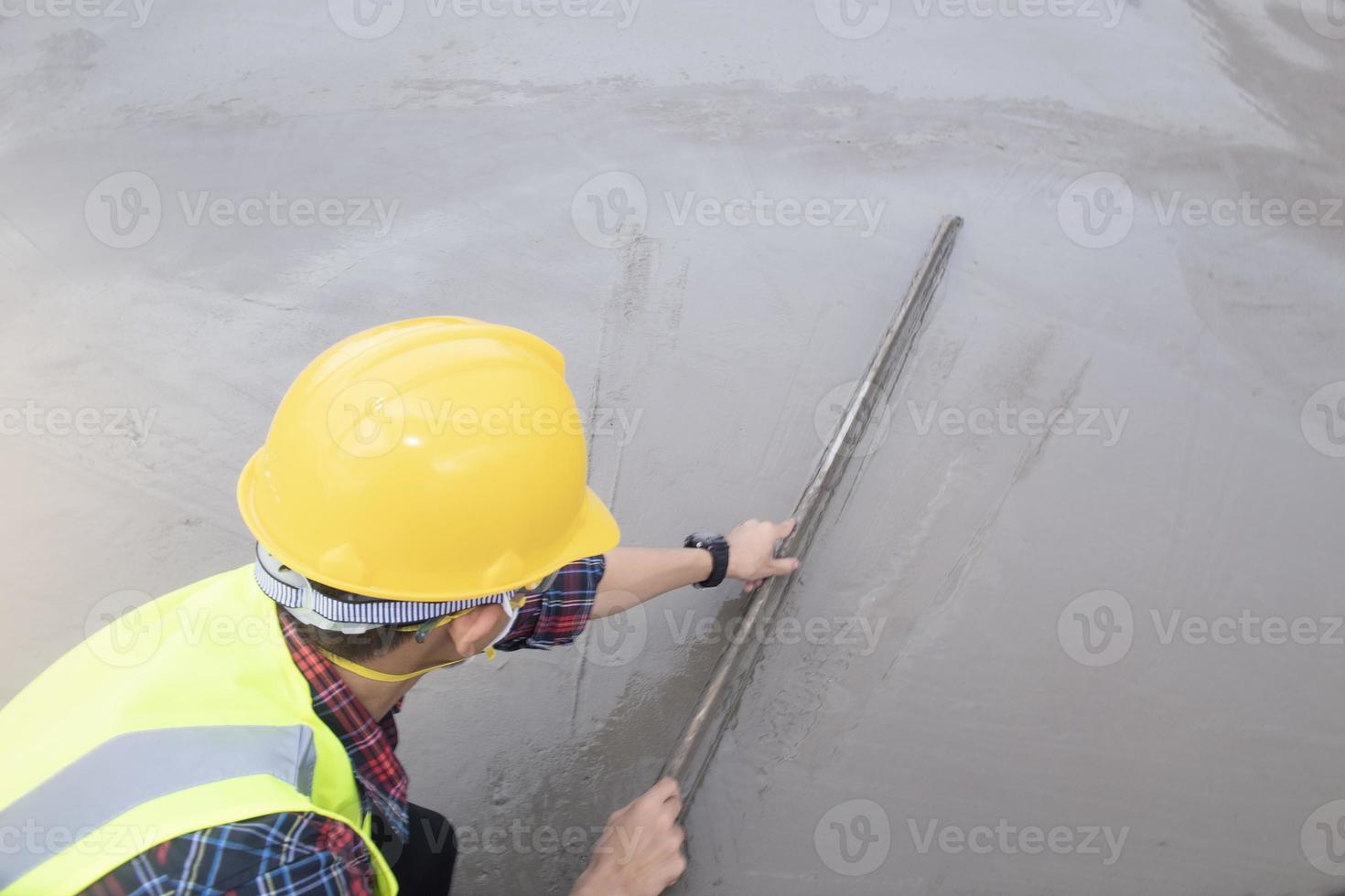 industrial worker with plastering tools renovating a house. builder worker plastering facade industrial building with leveler photo