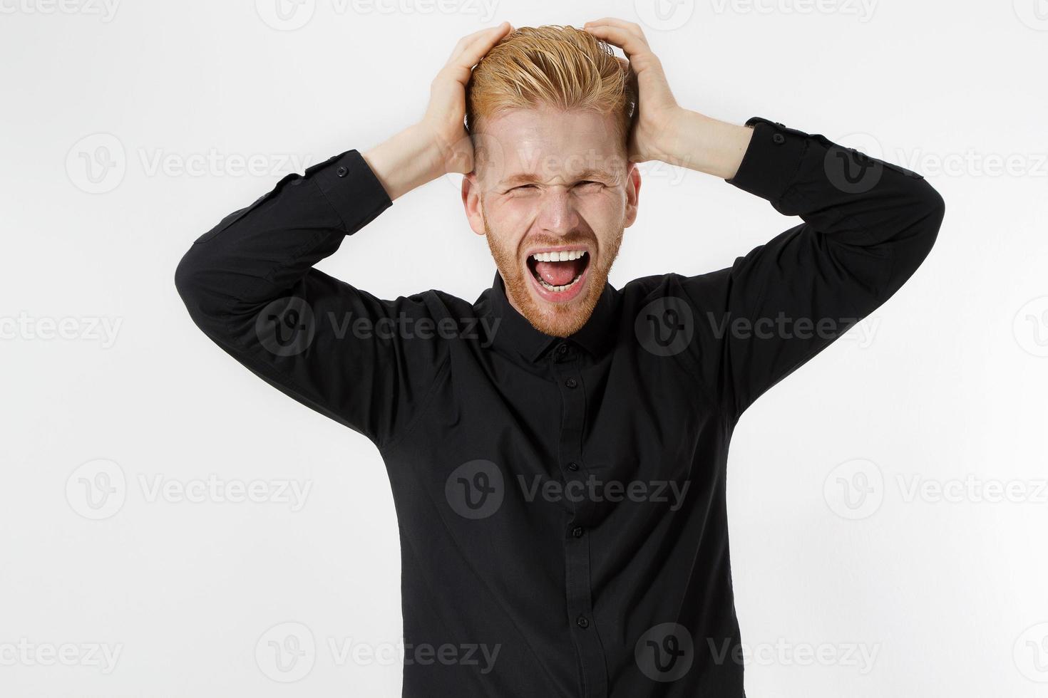Man Depression signs and Symptoms. Young redheaded guy with red beard and black shirt shouting hard and angry. Failed startup and fail exam concept. Unhappy businessman with aggressive feelings. photo