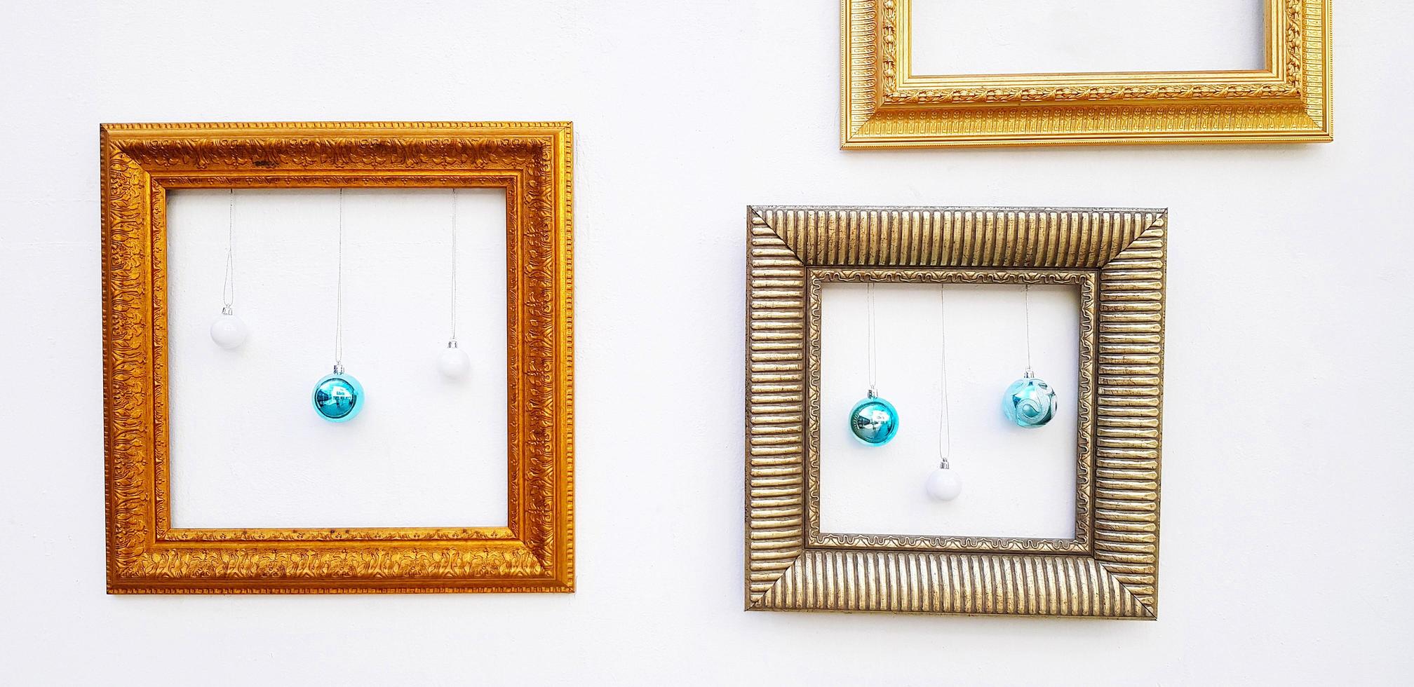 Many Yellow or Golden, brown picture frame mockup with blue ball and light bulb hanging on white concrete wall with copy space. Framework on background. Decorate for festival, Celebrate party. photo