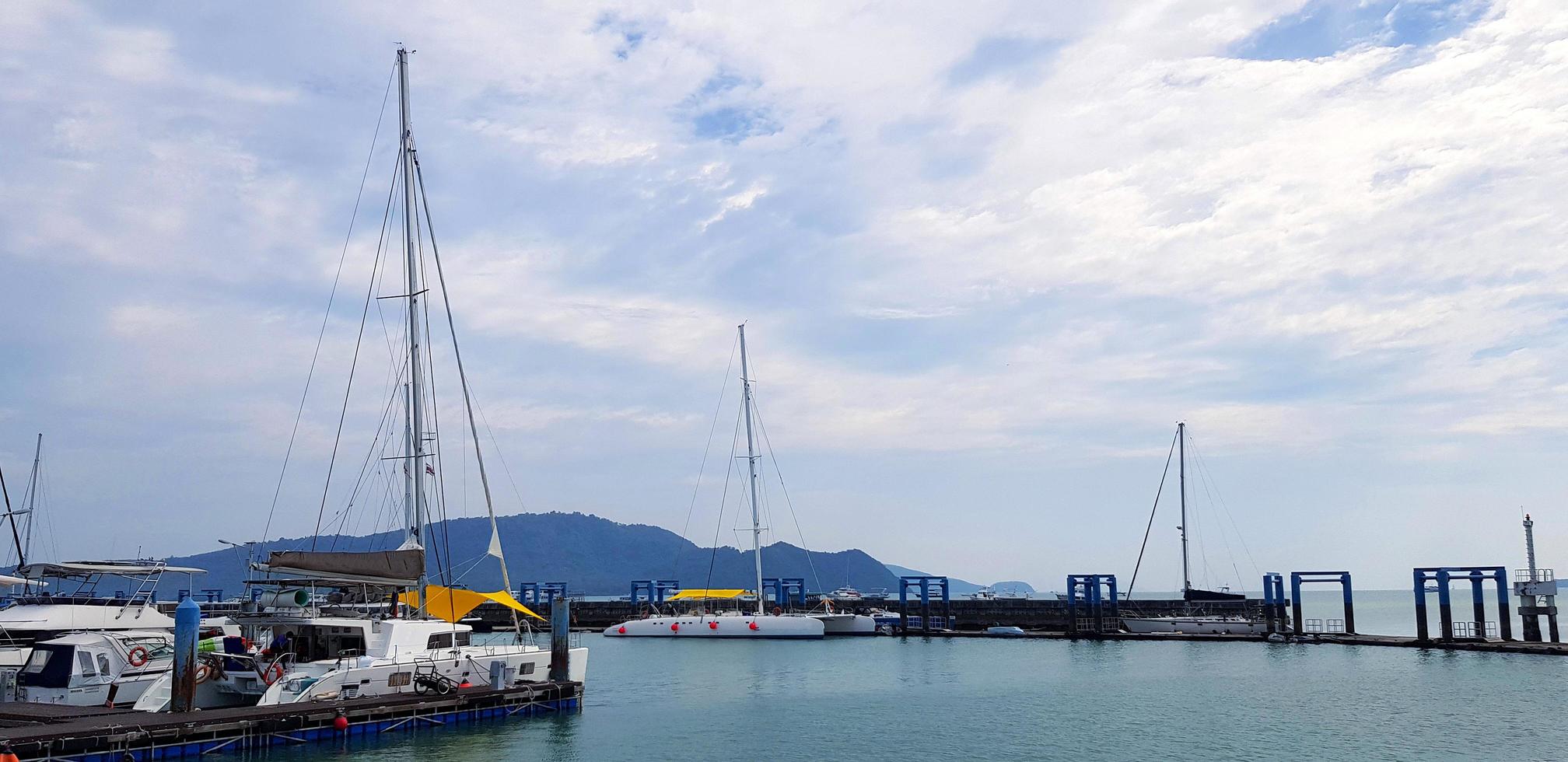 Many speed boats and yacht on the sea at port. Vehicle on ocean with blue sky and white cloud background with copy space on top or above. Landscape of view at Phuket, Thailand. Travel and Trip concept photo