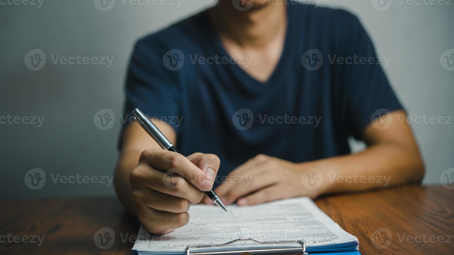 Businessman signs documents with a pen making the signature contract and partnership on desk. photo