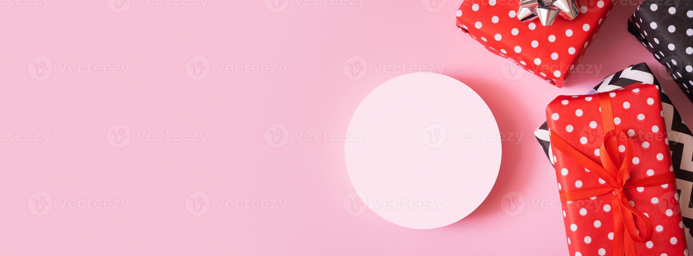 Product background for Christmas, New year and sale event concept. Gift boxes with ribbon bow and podium on pink background top view photo