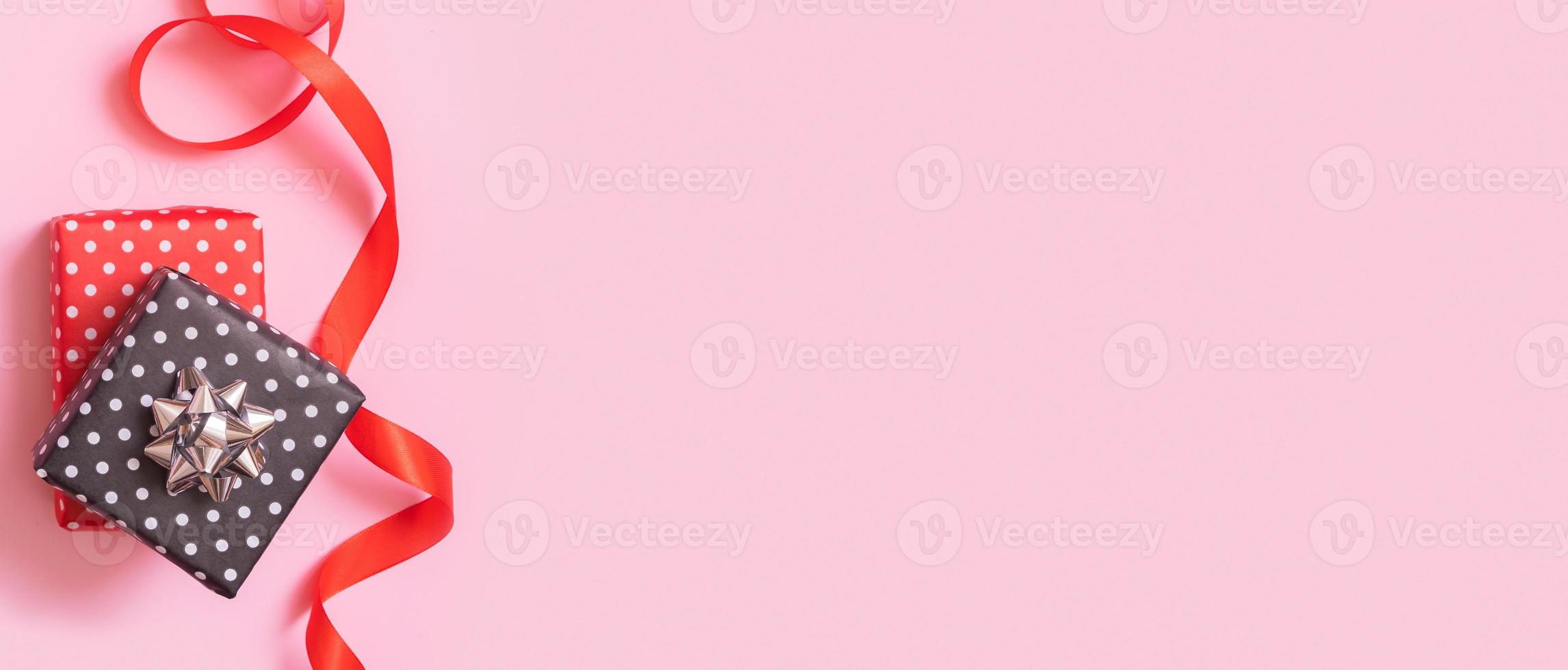 Banner with Christmas presents flat lay on a pink background. Top view xmas gift box with decorations photo