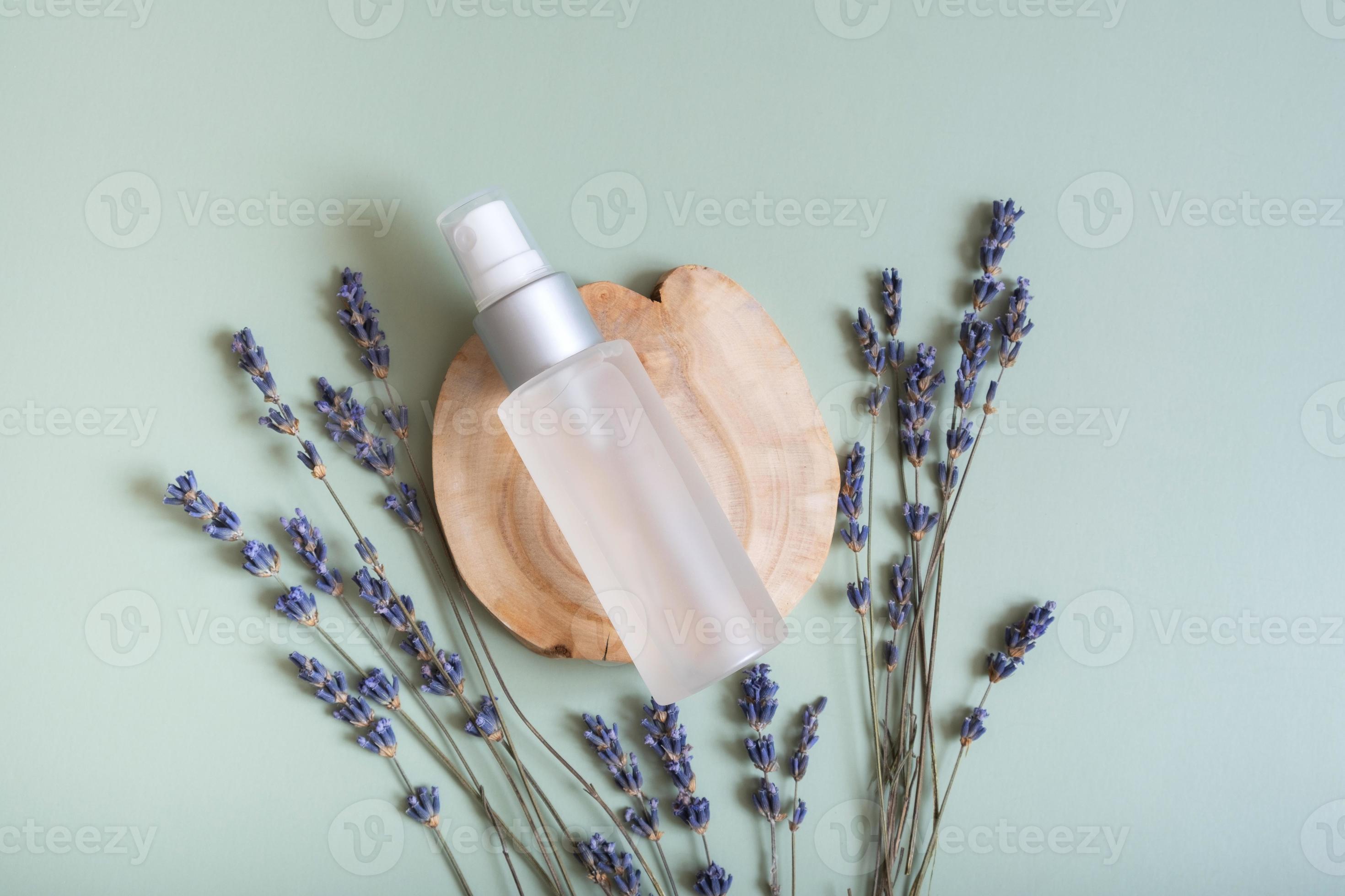 Cosmetic spray bottle on wooden slice top view, flat lay on colored