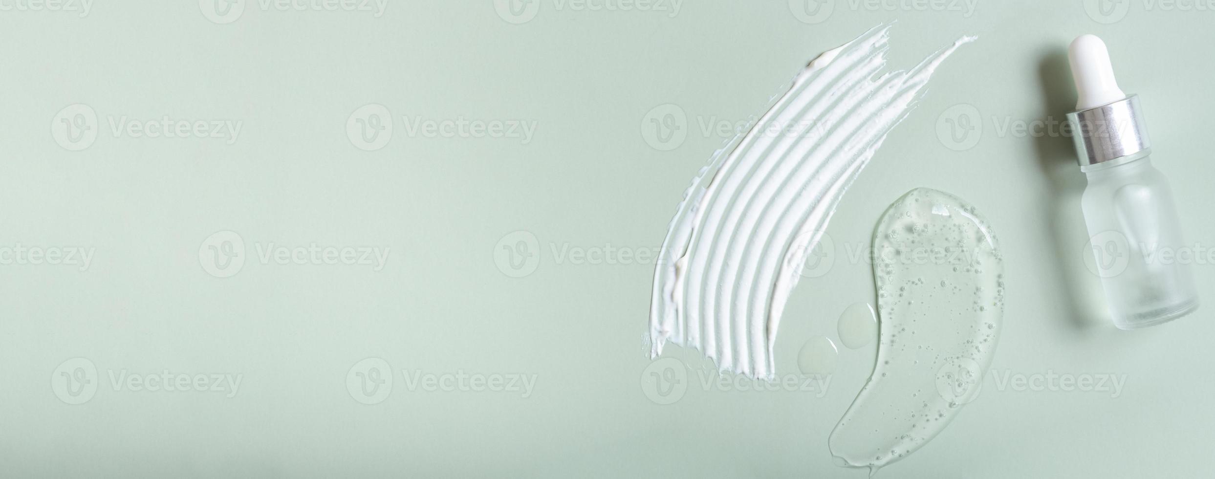 Cosmetic smears and pipette bottle on colored background top view. Banner format photo