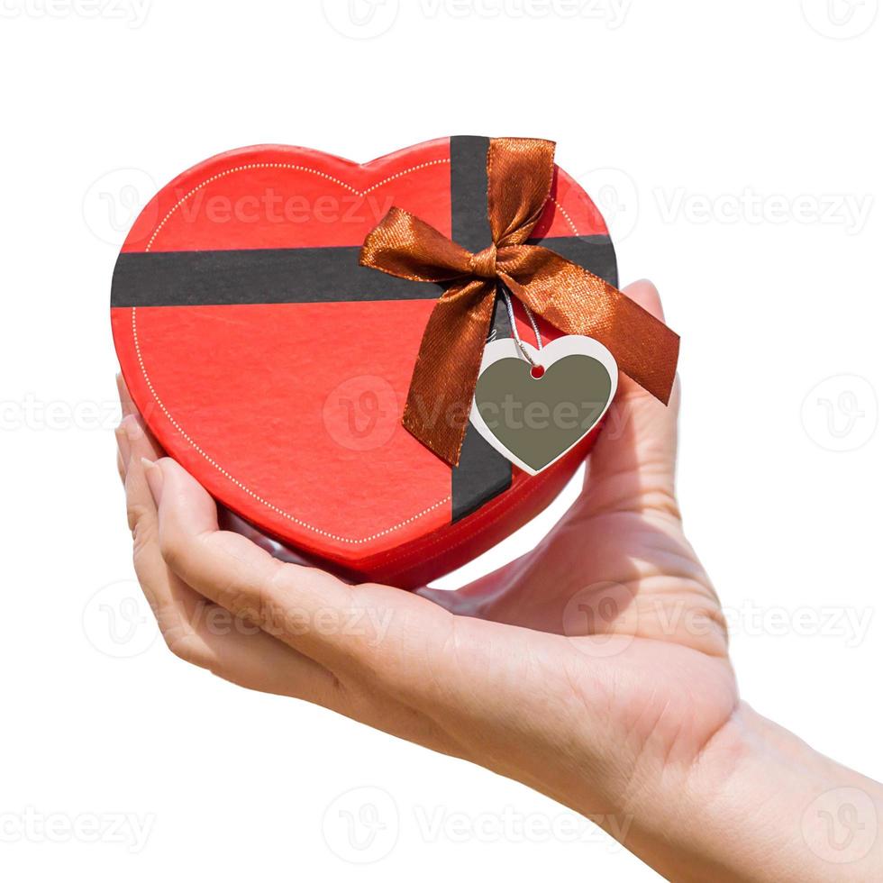 Hand holding a heart shaped box on white photo