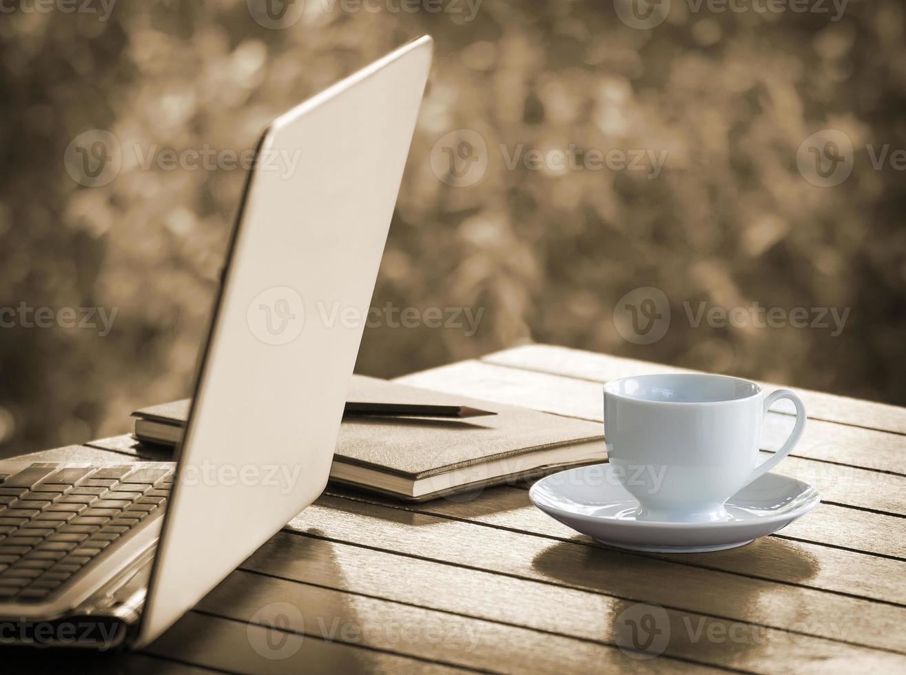 Laptop and Cup of coffee on desk photo