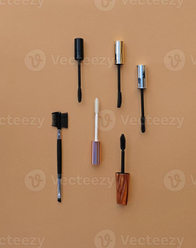 Flat lay makeup set for expressive eyelashes. Different shapes of mascara brushes, eyelash primer, eyebrow and eyelash brush. The concept of accessories, tools and cosmetics for the eyelashes. photo