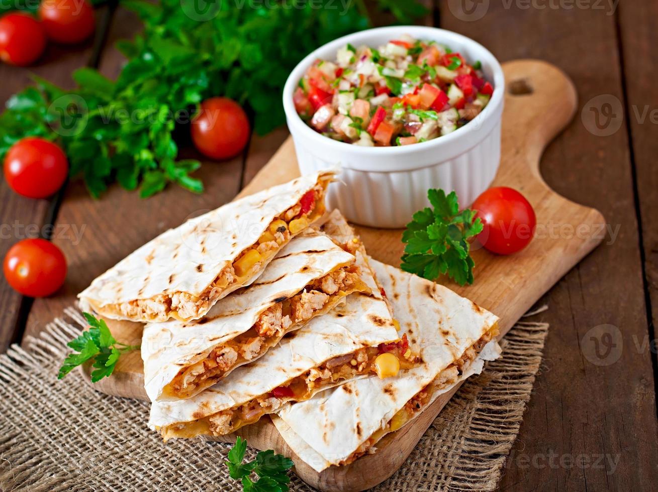 Mexican Quesadilla wrap with chicken, corn and sweet pepper and salsa photo