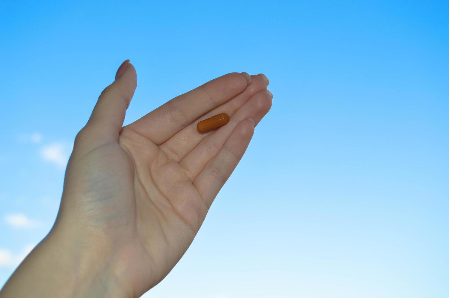 the medicine lies on the palm of a girl on a background of blue sky. intensive therapy for the treatment of acute viral infections. tablets for severe allergic reactions to pollen and dust photo