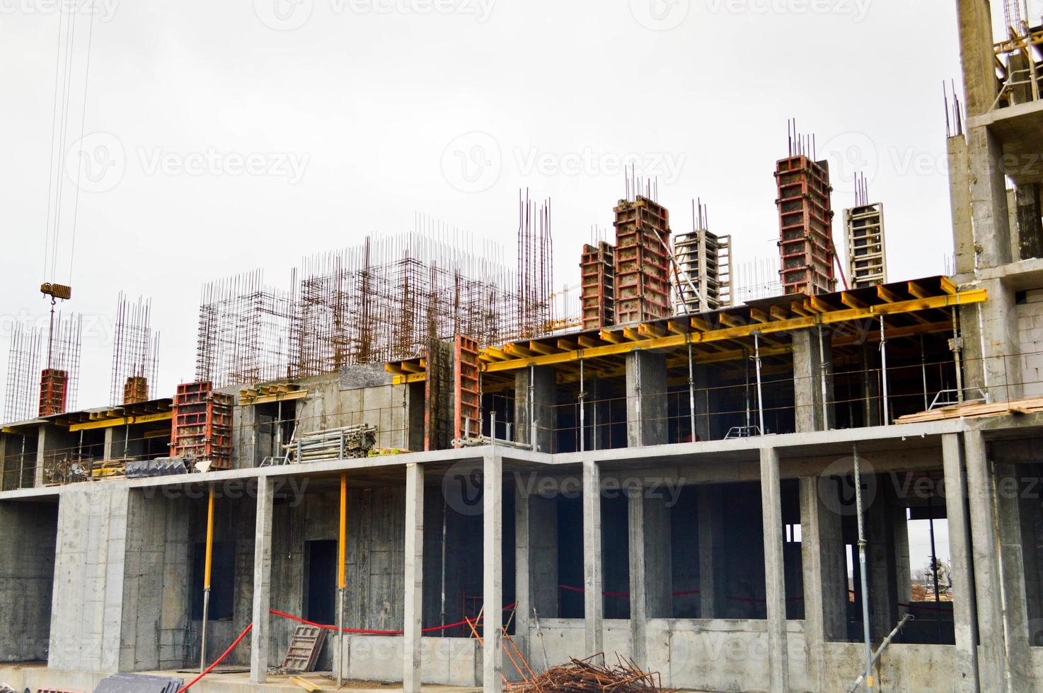 The process of construction and repair of a new modern cement concrete stone pannel monolithic frame-block building of a house with iron reinforcement at an industrial construction site photo
