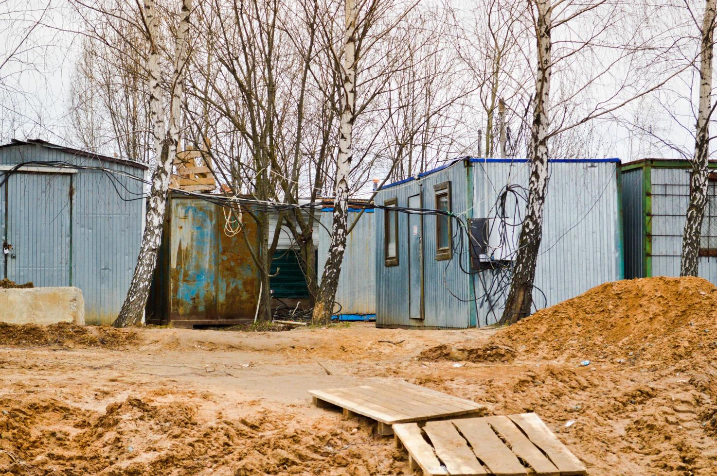 pequeñas casas temporales de constructores de contenedores en un sitio de construcción industrial. ciudad de construcción modular de bloques con casas de cambio para trabajadores foto