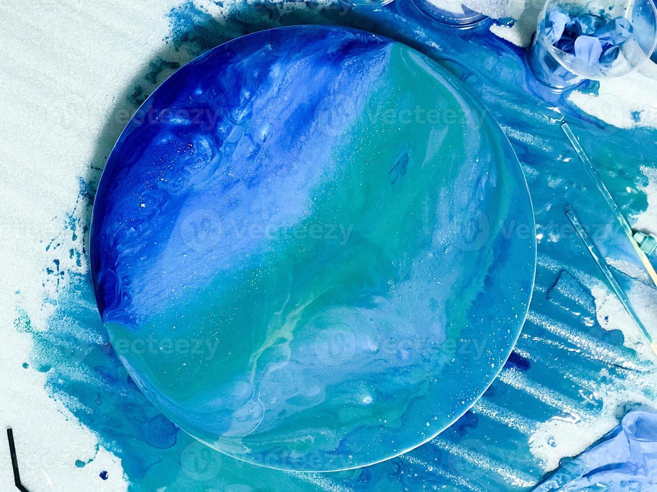 round abstract image using the technique of drawing with epoxy resin. blue-white sea on a wooden mold. paint on canvas. drawing interior pictures. contemporary art, filmed from above photo