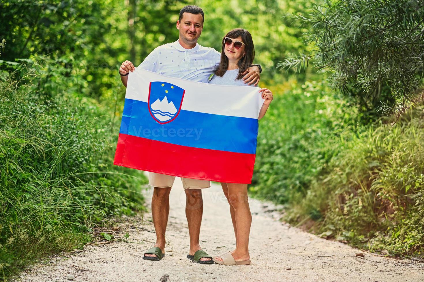 Couple hold slovenian flag in Triglav National Park, Slovenia. photo