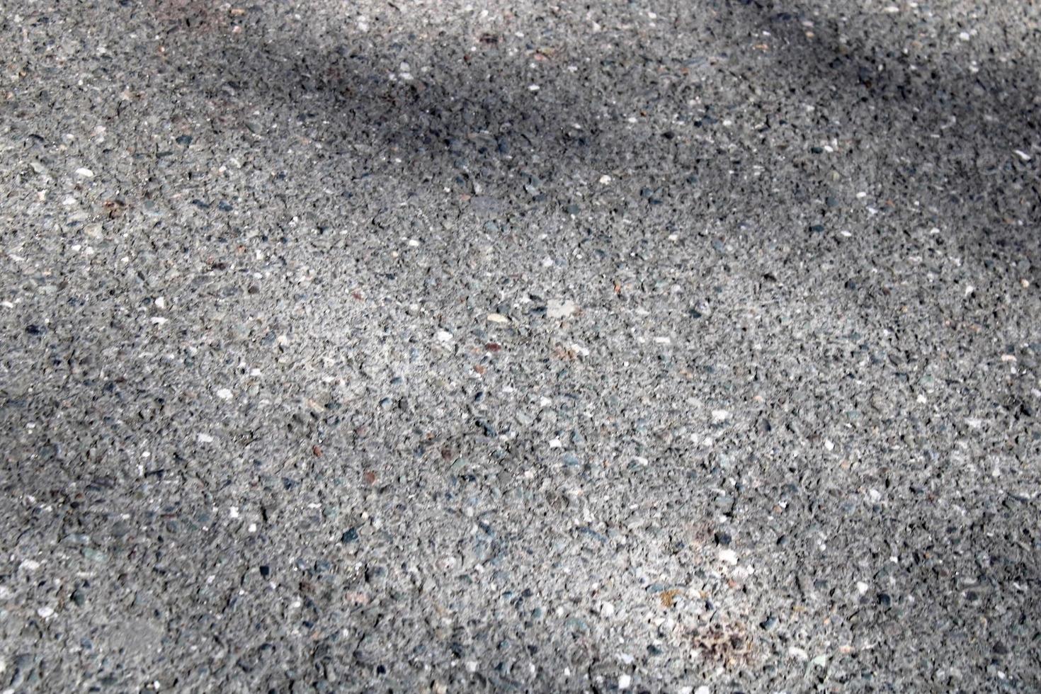 A light wall of stone chips with a shadow falling on it. The texture of