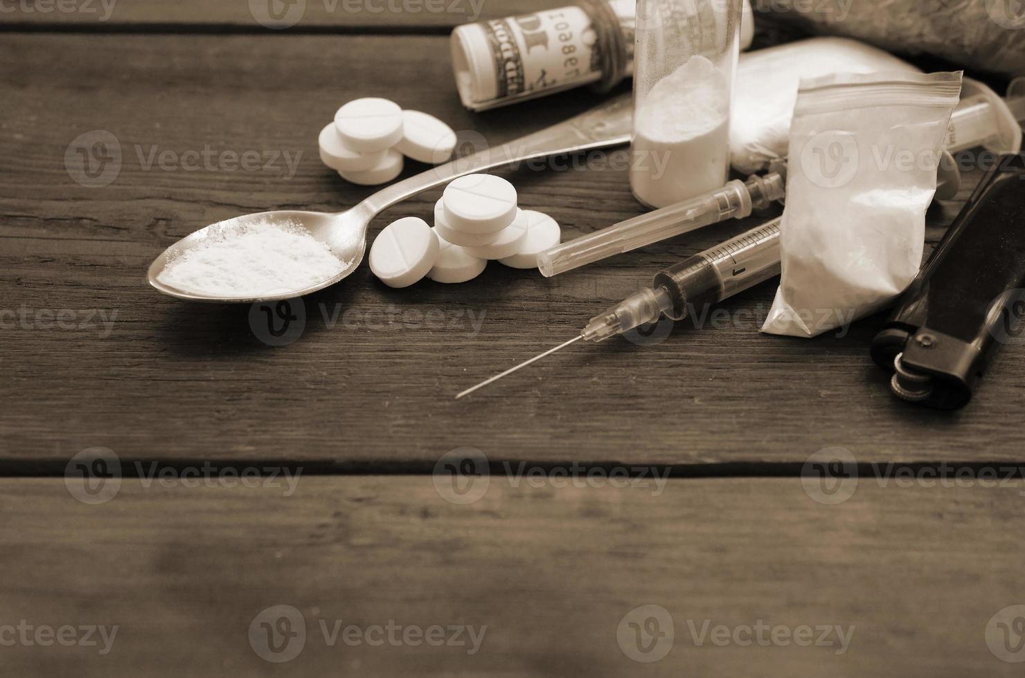 A lot of narcotic substances and devices for the preparation of drugs lie on an old wooden table photo