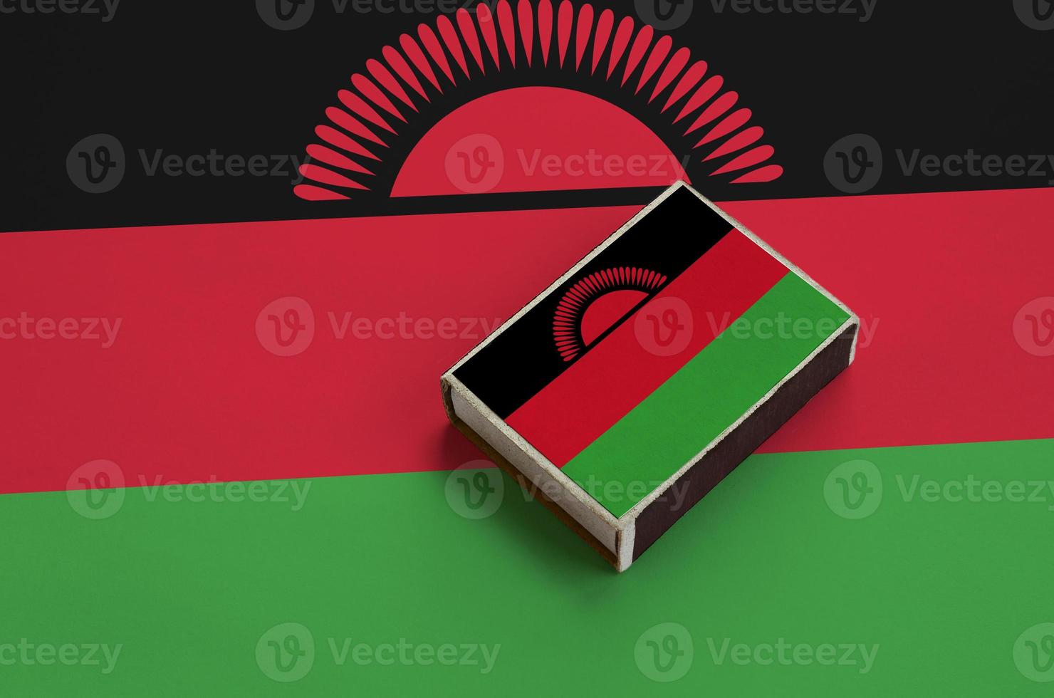 Malawi flag  is pictured on a matchbox that lies on a large flag photo