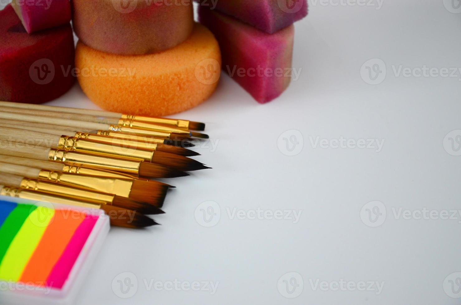 Color cosmetics, brushes and sponges for face painting on white background photo