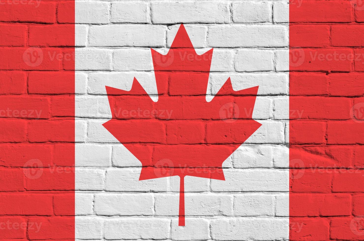 Canada flag depicted in paint colors on old brick wall. Textured banner on big brick wall masonry background photo