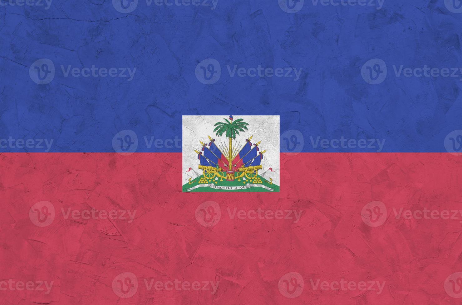 Haiti flag depicted in bright paint colors on old relief plastering wall. Textured banner on rough background photo