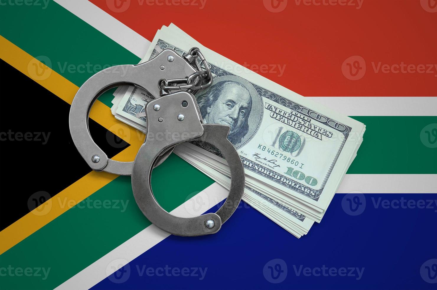 South Africa flag  with handcuffs and a bundle of dollars. Currency corruption in the country. Financial crimes photo