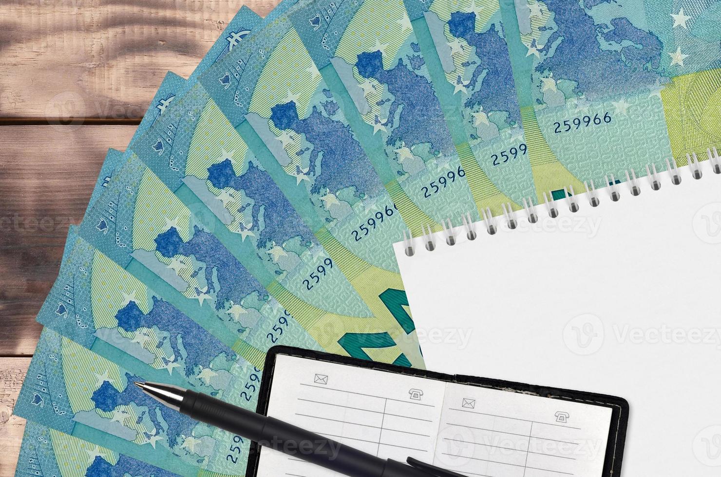 20 euro bills fan and notepad with contact book and black pen. Concept of financial planning and business strategy photo