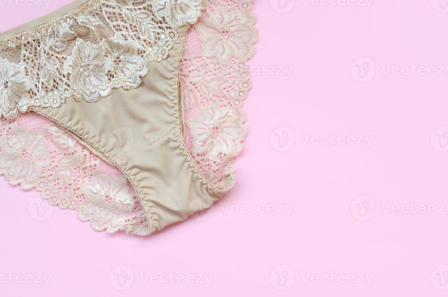 Beige women underwear with lace on pink background with copy space. Beauty fashion blogger concept. Romantic lingerie for Valentines day temptation photo