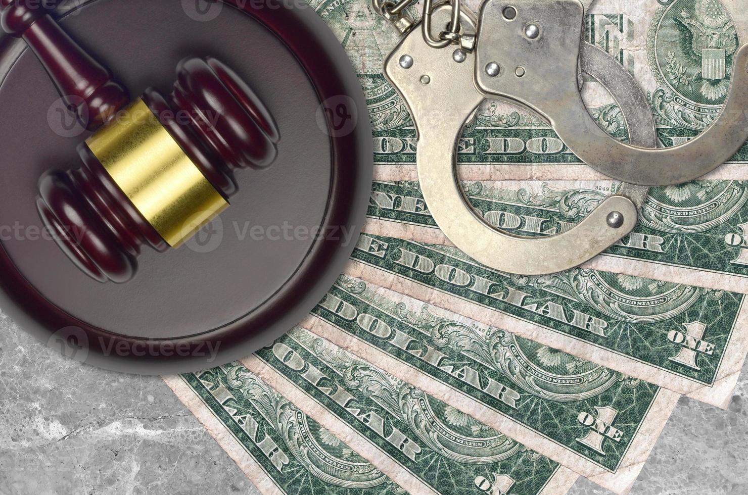 1 US dollar bills and judge hammer with police handcuffs on court desk. Concept of judicial trial or bribery. Tax avoidance photo