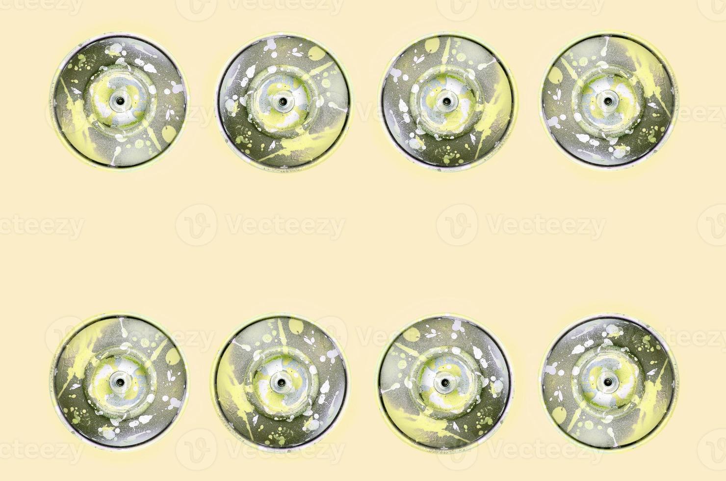 Many used spray cans for graffiti drawing lies on a pastel colored backgroung. Street art painting concept. Minimal flat lay pattern. Top view photo